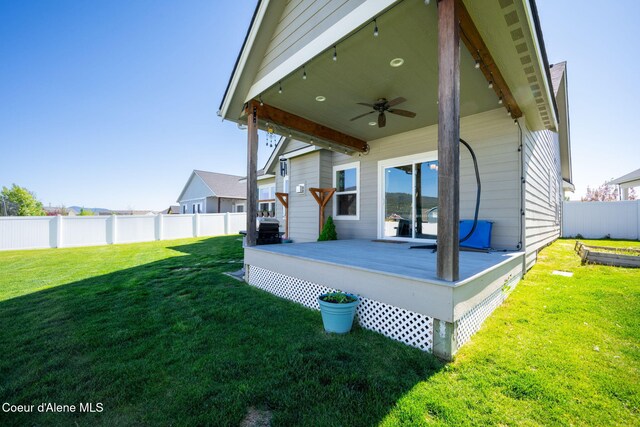 rear view of property featuring a ceiling fan and a wooden deck