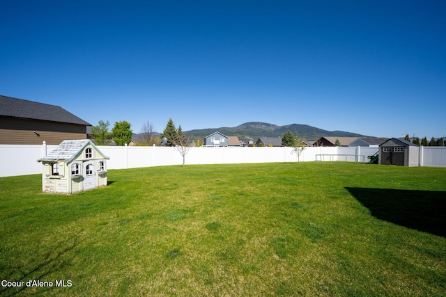 view of yard with a storage unit, an outdoor structure, and a mountain view