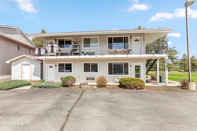 view of front of home with a balcony and stairway