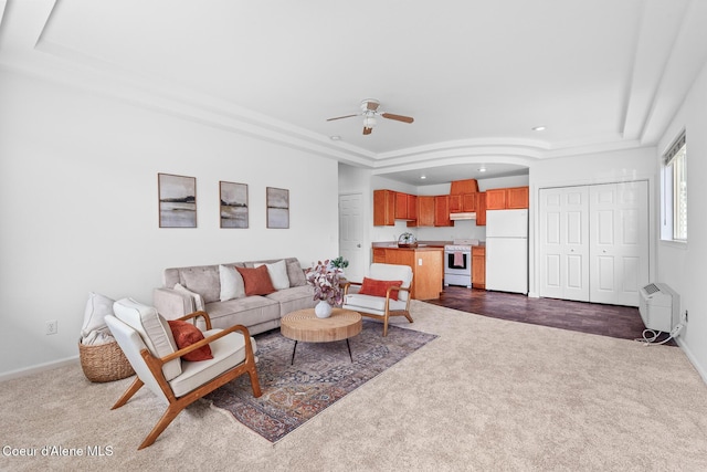 living area with a tray ceiling, recessed lighting, dark carpet, a ceiling fan, and baseboards