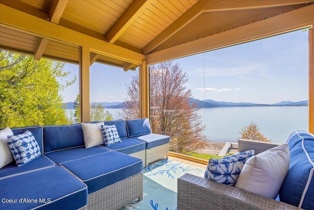 view of patio / terrace with an outdoor living space and a water and mountain view