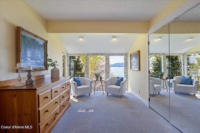 sitting room with carpet flooring, lofted ceiling, and baseboards