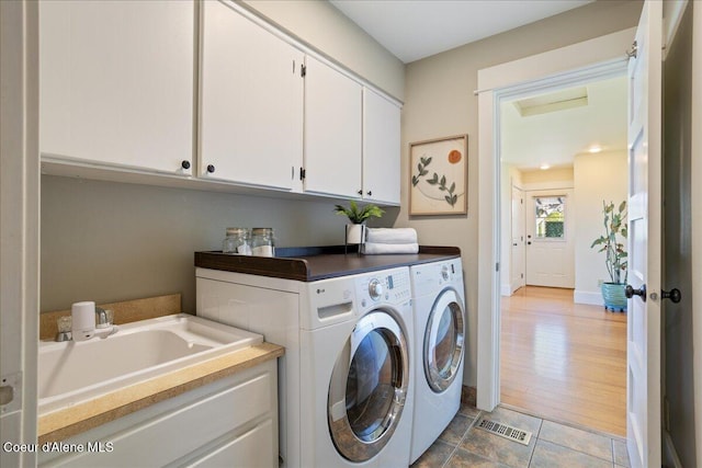 laundry area featuring washer and clothes dryer, cabinet space, and baseboards