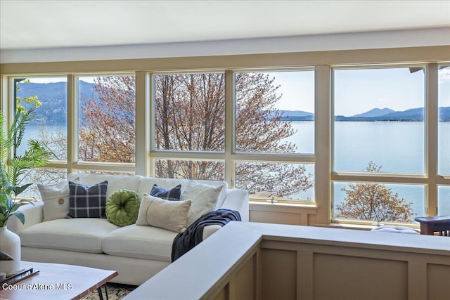 sunroom featuring a water and mountain view