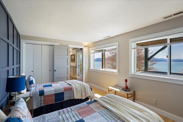 bedroom with baseboards, a closet, and light wood-style floors