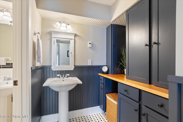 bathroom featuring wainscoting and a chandelier