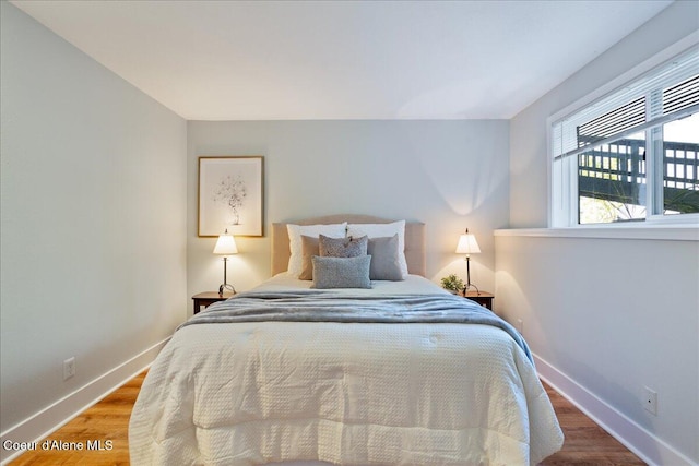 bedroom with baseboards and wood finished floors