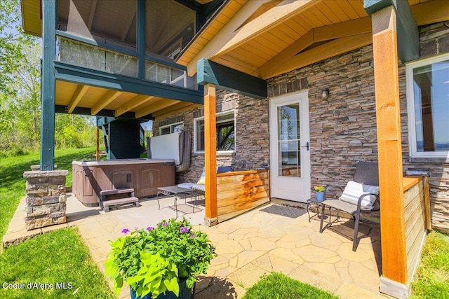 view of patio with a hot tub and a balcony