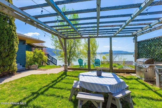 view of patio with a water view, area for grilling, and a pergola