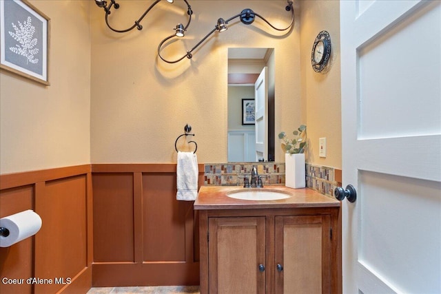 bathroom with vanity, a wainscoted wall, and decorative backsplash