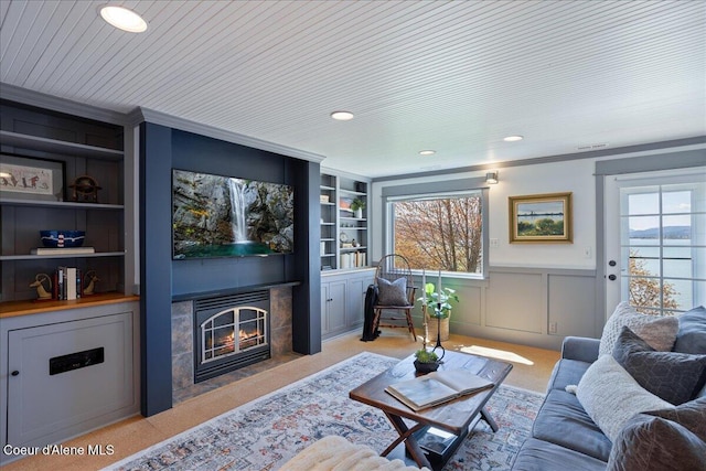 living area with built in features, carpet floors, plenty of natural light, wainscoting, and recessed lighting