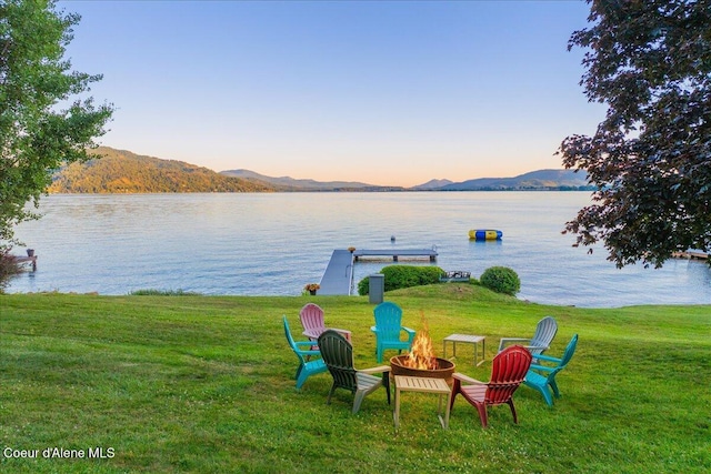 712 Ponder Point Dr, Sandpoint, ID 83864 - water view featuring a fire pit, a mountainous background, and a boat dock