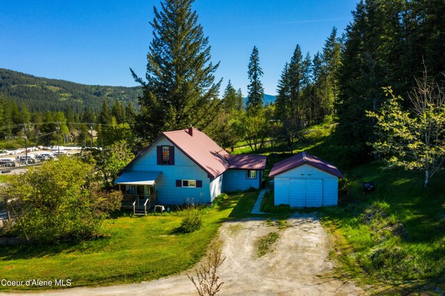 50 Smokehouse Rd, Sagle, ID 83860 - view of front facade with a forest view, driveway, an outdoor structure, a garage, and metal roof