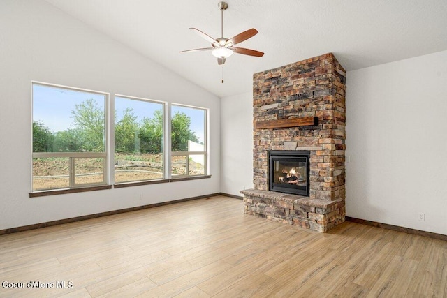 1451 W Tali Ave, Post Falls, ID 83854 - unfurnished living room with a ceiling fan, wood finished floors, lofted ceiling, and a stone fireplace