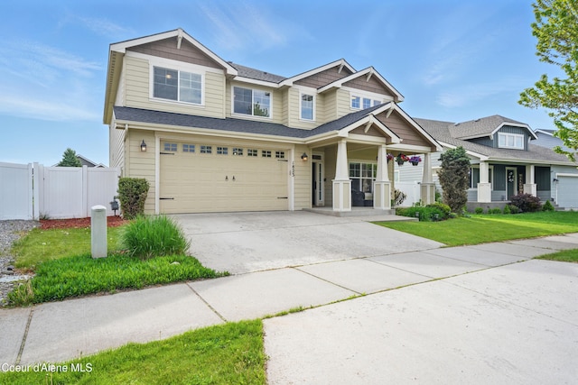 1823 N Clark Fork Pkwy, Post Falls, ID 83854 - craftsman house with a porch, an attached garage, concrete driveway, and roof with shingles