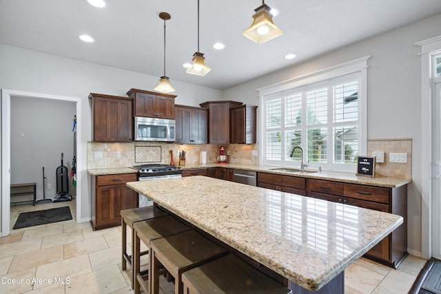 1823 N Clark Fork Pkwy, Post Falls, ID 83854 - kitchen with stainless steel appliances, a sink, tasteful backsplash, pendant lighting, and light stone counters