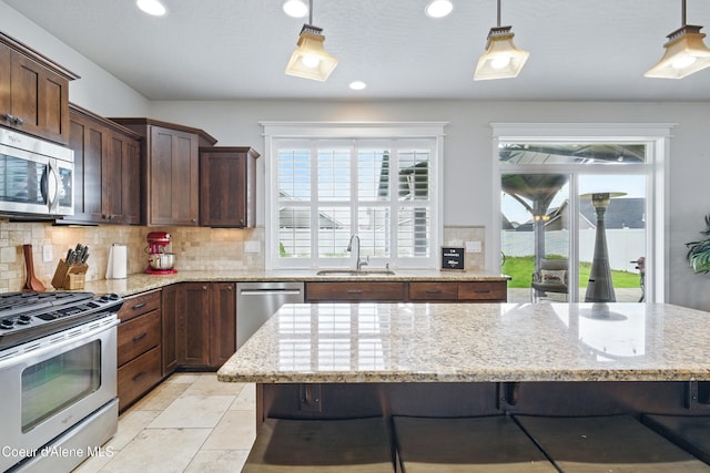 1823 N Clark Fork Pkwy, Post Falls, ID 83854 - kitchen featuring stainless steel appliances, a sink, tasteful backsplash, light stone countertops, and recessed lighting
