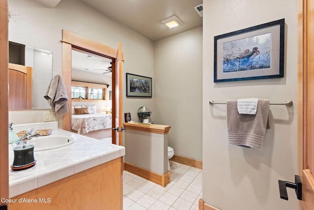 679 Comeback Bay Ln, Sagle, ID 83860 - bathroom featuring toilet, vanity, tile patterned floors, baseboards, and ensuite bathroom