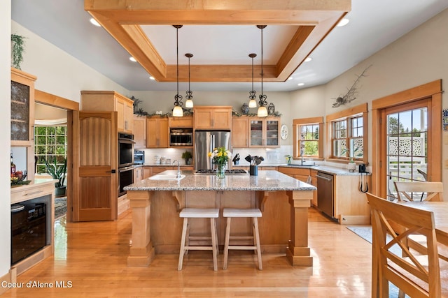 679 Comeback Bay Ln, Sagle, ID 83860 - kitchen featuring appliances with stainless steel finishes, a sink, beverage cooler, light wood finished floors, and recessed lighting