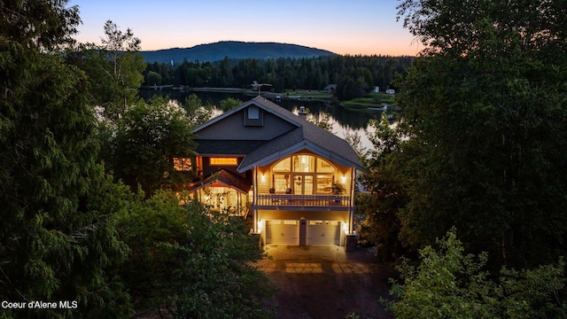 679 Comeback Bay Ln, Sagle, ID 83860 - view of front of house featuring a wooded view, driveway, an attached garage, and a water and mountain view