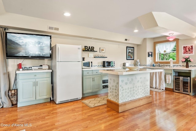 679 Comeback Bay Ln, Sagle, ID 83860 - kitchen featuring white appliances, beverage cooler, light countertops, light wood-style flooring, and recessed lighting