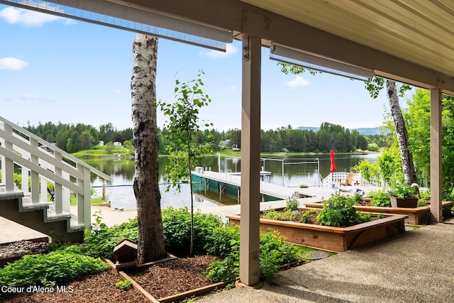 679 Comeback Bay Ln, Sagle, ID 83860 - view of patio featuring a water view, view of wooded area, a garden, and a boat dock