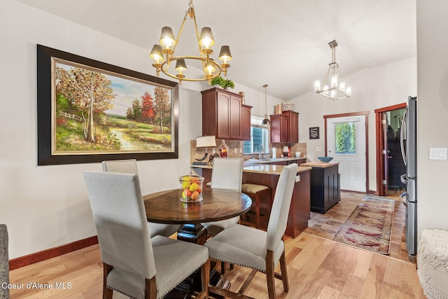 3313 N Rosalia Rd, Coeur Dalene, ID 83814 - dining space with a chandelier, light wood-type flooring, lofted ceiling, and baseboards