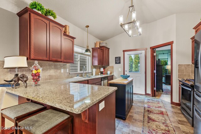 3313 N Rosalia Rd, Coeur Dalene, ID 83814 - kitchen with a sink, appliances with stainless steel finishes, decorative backsplash, vaulted ceiling, and a peninsula