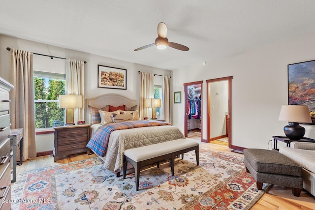 3313 N Rosalia Rd, Coeur Dalene, ID 83814 - bedroom featuring multiple windows, light wood-style floors, a spacious closet, and a ceiling fan