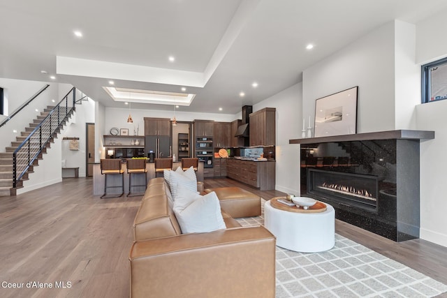 2855 W Lumber Ln, Coeur Dalene, ID 83814 - living room featuring light wood finished floors, stairs, baseboards, recessed lighting, and a raised ceiling