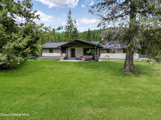 435 Shady Pines Loop, Priest Lake, ID 83856 - view of front of property featuring metal roof, a front yard, a standing seam roof, a patio, and a chimney