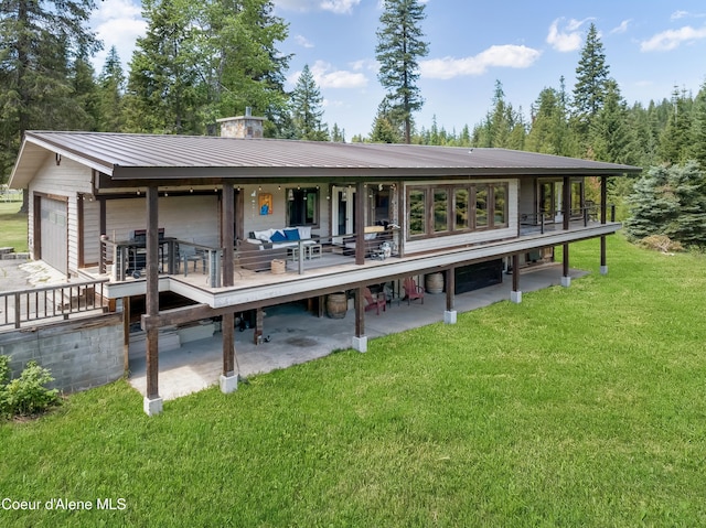 435 Shady Pines Loop, Priest Lake, ID 83856 - back of property with a lawn, metal roof, a wooden deck, and a patio area