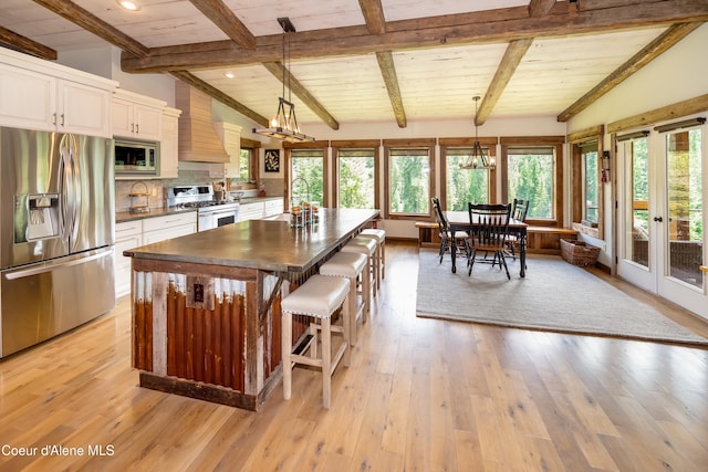 435 Shady Pines Loop, Priest Lake, ID 83856 - kitchen with appliances with stainless steel finishes, dark countertops, premium range hood, white cabinetry, and a sink