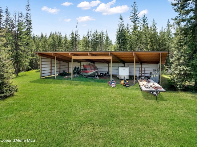 435 Shady Pines Loop, Priest Lake, ID 83856 - view of parking featuring a detached carport, water heater, and an outbuilding