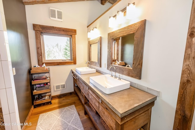 435 Shady Pines Loop, Priest Lake, ID 83856 - bathroom featuring double vanity, wood finished floors, baseboards, and vaulted ceiling