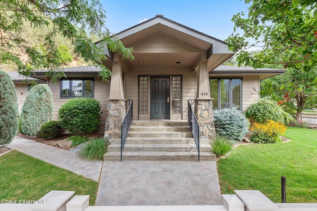 view of exterior entry with a yard
