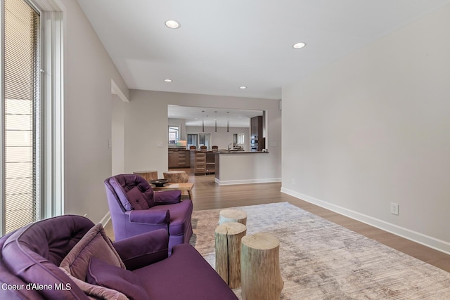 living area with wood finished floors, recessed lighting, and baseboards