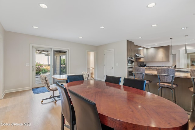 dining space featuring light wood finished floors, recessed lighting, and baseboards