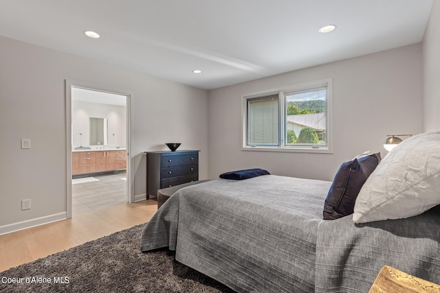 bedroom featuring light wood finished floors, recessed lighting, ensuite bathroom, and baseboards