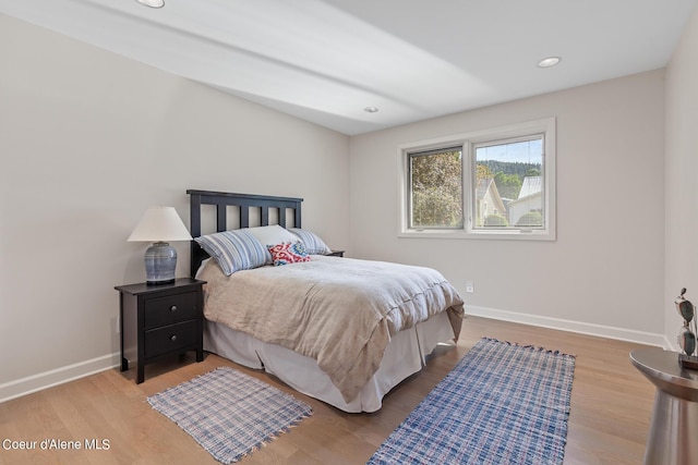 bedroom featuring baseboards, wood finished floors, and recessed lighting