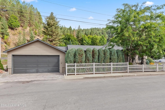 view of front of property featuring a garage and a view of trees