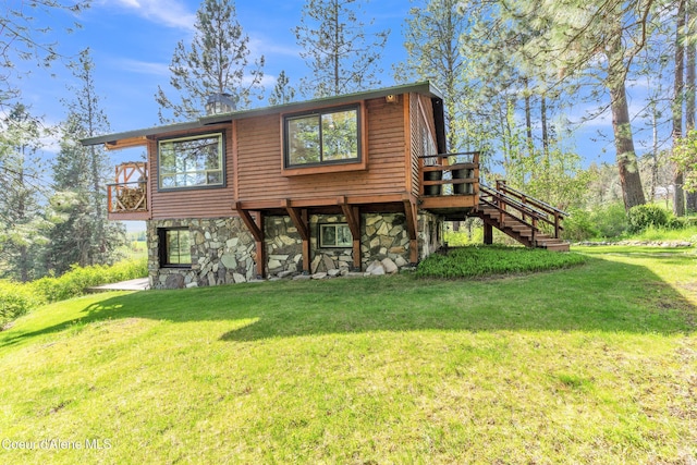 3226 District Two Rd, Bonners Ferry, ID 83805 - rear view of property featuring stairway, stone siding, a lawn, and a deck