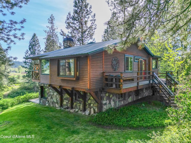 3226 District Two Rd, Bonners Ferry, ID 83805 - view of side of home with a wooden deck, a chimney, a lawn, and stairway