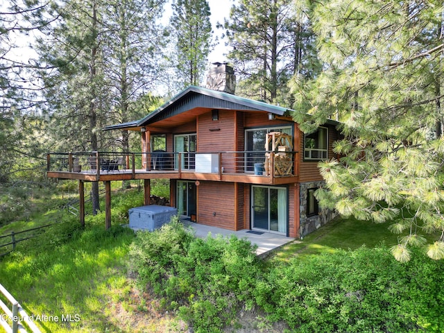 3226 District Two Rd, Bonners Ferry, ID 83805 - rear view of property with a chimney, a patio area, a deck, and a lawn