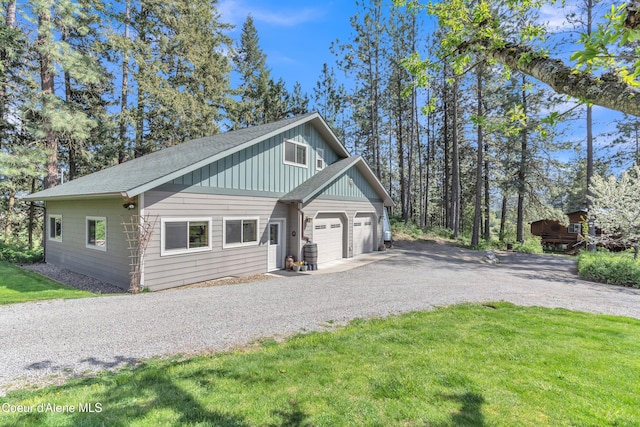 3226 District Two Rd, Bonners Ferry, ID 83805 - view of side of home featuring a lawn, board and batten siding, an attached garage, gravel driveway, and a shingled roof