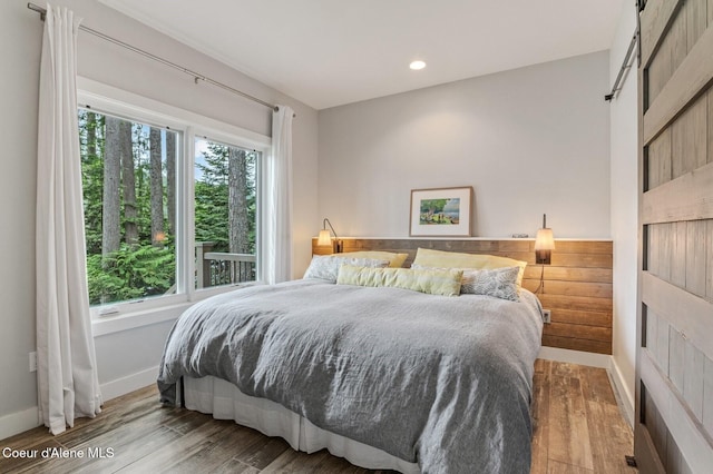 130 Cedar Shls, Sagle, ID 83860 - bedroom featuring baseboards, wood finished floors, recessed lighting, and a barn door