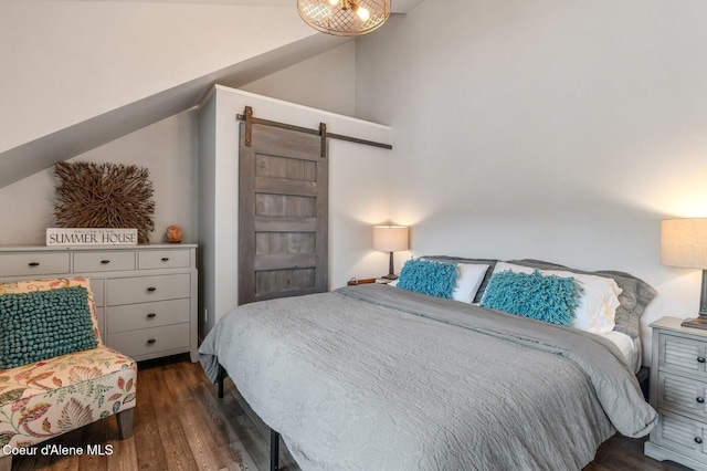 130 Cedar Shls, Sagle, ID 83860 - bedroom with a barn door, dark wood finished floors, and lofted ceiling