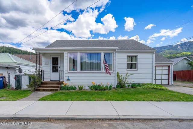 bungalow featuring a garage, driveway, and roof with shingles