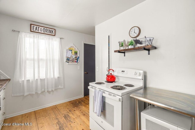 kitchen featuring white electric range, light wood-style flooring, and baseboards