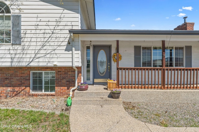 29 Silver Mountain Ln, Oldtown, ID 83822 - doorway to property with a chimney, a porch, and brick siding